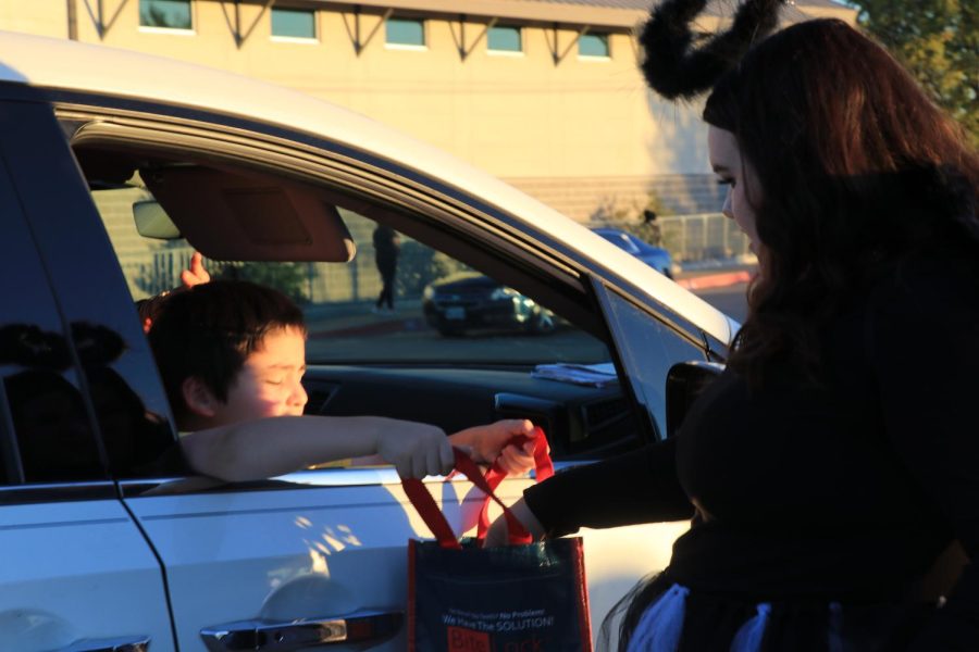 Senior Adisyn Torres passes out handfuls of candy on Halloween.