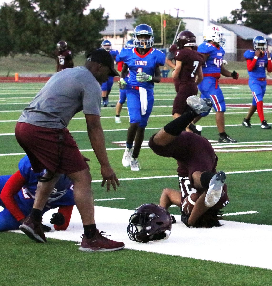 Tough Hit. Upside down, junior Cam'Rhan Jones loses his helmet after the play against a South Garland Titan defender. Later during this same JV game Jones broke his leg and was out the rest of the season.