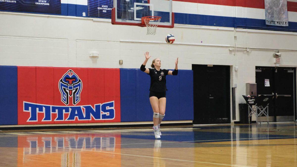 Varsity co-captain, Katie Levvis (11) serves against South Garland.